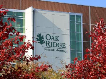Oak Ridge National Laboratory sign framed by red leaves.