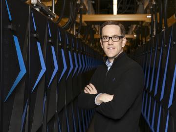 Paul Kent, shown above posing with Summit in April 2018, received the 2020 ORNL Director’s Award for Outstanding Individual Accomplishment in Science and Technology. Credit: ORNL, U.S. Dept. of Energy