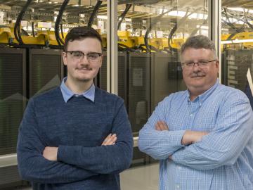 Tyler Duckworth, left, poses with his father, Robert Duckworth, in front of the Summit supercomputer.  Tyler Duckworth has been named recipient of the 2021 UT-Battelle Scholarship to attend the University of Tennessee. Credit: Carlos Jones/ORNL, U.S. Dept. of Energy