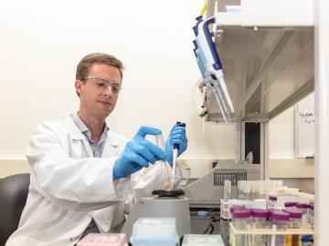ORNL’s Josh Michener, a microbiologist and metabolic engineer, led the discovery of a useful new enzyme that breaks down stubborn bonds in lignin, a polymer found in plants that typically becomes waste during bioconversion. Credit: Carlos Jones/ORNL, U.S. Dept. of Energy