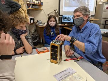 Peter Thornton, right, works with Robertsville Middle School students to assemble the RamSat. Credit: Ian Goethert/ORNL, U.S. Dept. of Energy