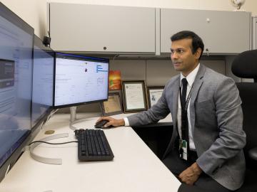 Researcher Gautam Thakur works at his desk.