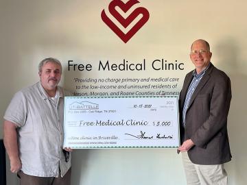 Alan Icenhour, right, ORNL deputy director for laboratory operations, presents Billy Edmonds, executive director of the Free Medical Clinic, with a check during a celebration on Oct. 18 in Briceville. Credit: ORNL, U.S. Dept. of Energy