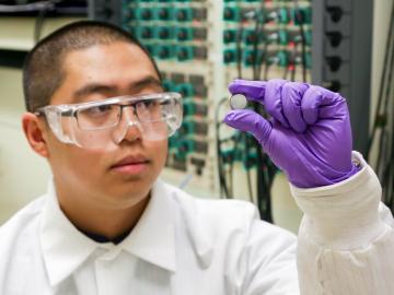 ORNL postdoctoral researcher Runming Tao, pictured with a coin cell battery, led an effort to discover new anode materials for fast-charging lithium-ion batteries. Credit: ORNL/Genevieve Martin, U.S. Dept. of Energy