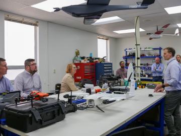 People around a table with drones