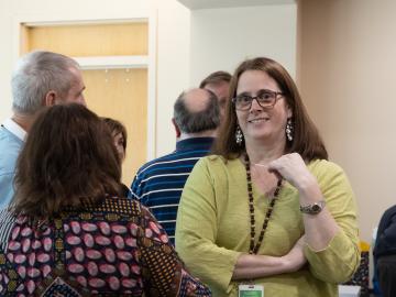 Photograph of Jennifer Shell speaking with colleagues at an ORNL function