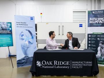 ZEISS Head of Additive Manufacturing Technology Claus Hermannstaedter, left, and ORNL Interim Associate Laboratory Director for Energy Science and Technology Rick Raines sign a licensing agreement that allows ORNL’s machine-learning algorithm, Simurgh, to be used for rapid evaluations of 3D-printed components with industrial X-ray computed tomography, or CT. Using machine learning in CT scanning is expected to reduce the time and cost of inspections of 3D-printed parts by more than ten times.