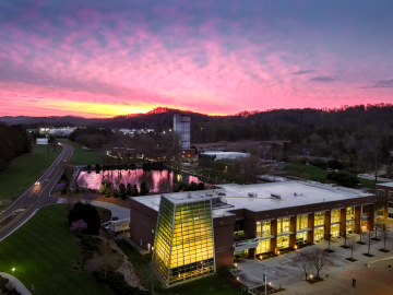 The sun sets behind the ORNL Visitor Center in this aerial photo from April 2023. Credit: Kase Clapp/ORNL, U.S. Dept. of Energy