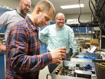 ORNL quantum researchers, from left, Brian Williams, Phil Evans, and Nick Peters work on their quantum key distribution system. 