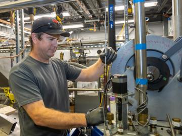 A technician works on the machinery that generates the the Fundamental Neutron Physics Beamline at the Spallation Neutron Source.