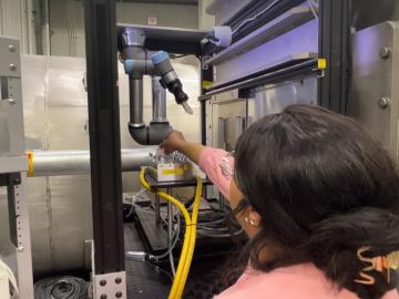 ORNL researcher Felicia Gilliland loads experiment samples into position for the newly installed UR5E robotic arm at the BIO-SANS instrument. The industrial-grade robot changes samples automatically, reducing the need for human assistance and improving sample throughput. Credit: Jeremy Rumsey/ORNL, U.S. Dept. of Energy