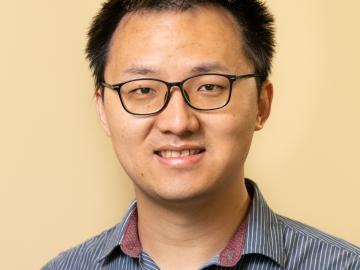 Man in glasses smiles for a photo