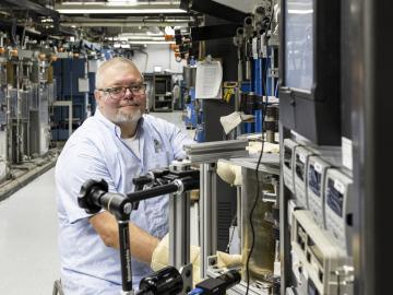 Jeremy Moser, a technician at the Physical Sciences Directorate, poses in the testing laboratory where he studies how materials react under extreme pressure.