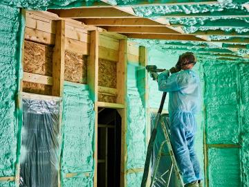 Worker spraying foam insulation