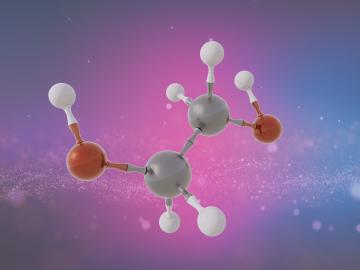The image depicts a molecule made up of 6 white balls, two smaller red balls and two larger grey balls. This molecule is against a pink, blue and purple background. 