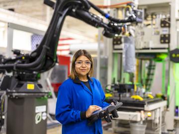 Researcher Brittany Rodriguez works with an ORNL-developed Additive Manufacturing/Compression Molding system that 3D prints large-scale, high-volume parts made from lightweight composites. Credit: Carlos Jones/ORNL, U.S. Dept. of Energy