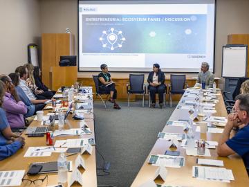 Angelique Adams, front left, introduces Kusum Rathore, front center, executive director and vice president of the multi-campus office at the University of Tennessee Research Foundation, and Jim Biggs, executive director of the Knoxville Entrepreneur Center, during the final presentation event for ORNL’s Safari coaching program.