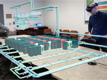 From left, Sedrick Bouknight and Matthias Maiterth of ORNL’s Analytics and AI Methods at Scale group demonstrate the VR capabilities of the Frontier digital twin project's ExaDIGIT framework. Using VR allows Frontier's operators to exam the system's telemetry in a more interactive and intuitive way.