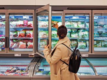 Woman shops for frozen food. Envato