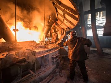 Steelworker at work near the arc furnace. Envato