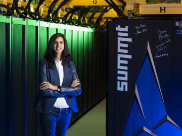 Supriya Chinthavali is standing with the Summit supercomputer at ORNL