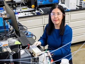 Mengya Li is pictured here sitting at a computer in a lab.