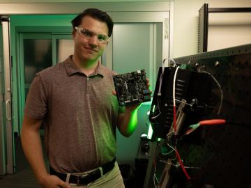 Andrew Tabaczynski, ORNL intern, poses with a circuit board.