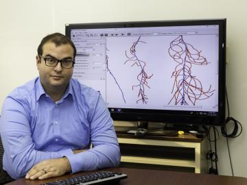 Larry York is sitting in front of a computer screen showing an image of plant phenotyping