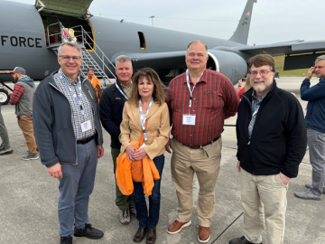 ORNL staff including 4 guys and one girl stand outside of the Bosslift airplane