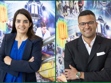 Verónica Melesse Vergara and Felipe Polo-Garzon pose in front of ORNL mural for photo with their arms crossed