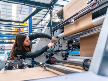 Engineer working on a machine making packaging. Envato