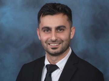 Emrullah Aydin, an ORNL research is posing for a headshot in a black suit with black tie