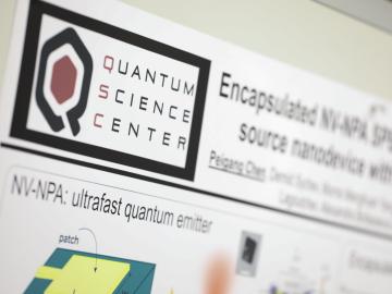 Close up image of Quantum Science Center poster with the QSC logo. 