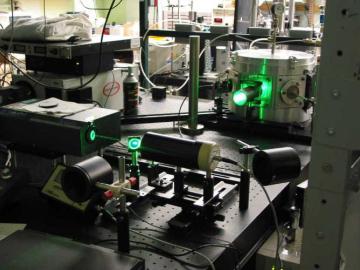 Laser equipment and optical devices on an experiment table in a scientific research laboratory.