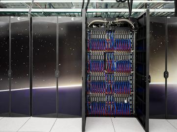 Two cabinets of ORNL's Frontier supercomputer are open to show the blue and red cords on the inside. 
