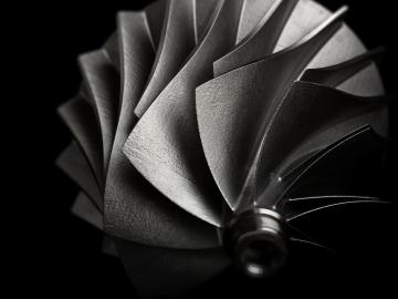Close up photo of components for jet engines, fanned out in a spiral from the center