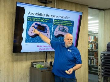 ORNL researcher Thomas Proffen presents a slide on assembling a game controller to a class of STEM students