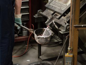 Alloyed metals being poured from a furnace into a ladle, to be used to fill molds. Image credit: Zachary Sims, ORNL Alloyed metals being poured from a furnace into a ladle, to be used to fill molds. Image credit: Zachary Sims, ORNL
