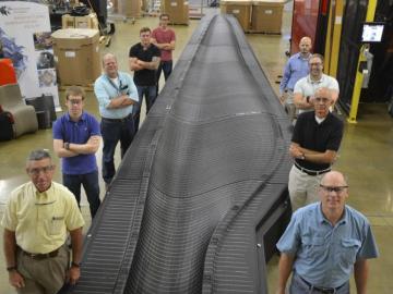 Researchers give perspective to the size of the assembled wind blade mold at DOE’s Manufacturing Demonstration Facility at ORNL. Left side, front to back: Peter Lloyd, Alex Roschli, Lonnie Love, Matt Sallas, John Lindahl. Right side, F-B: David Nuttall, R
