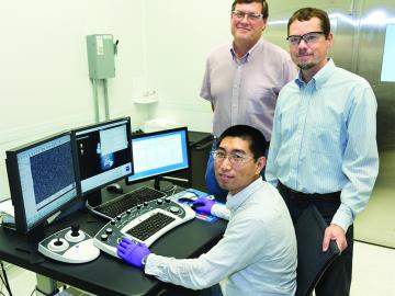 ORNL’s Yang Song, seated, Dale Hensley, standing left, and Adam Rondinone examine a carbon nanospike sample with a scanning electron microscope. (ORNL photo by Genevieve Martin) 