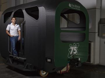 Adian Cook standing in front of GROVER autonomous bus