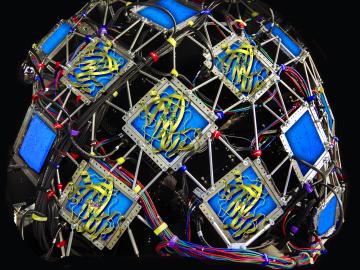 An artist’s rendering of the five protein structures solved using neutrons shown on top of the MaNDi instrument detectors. Image credit - ORNL/DOE