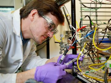 Alex Lewis, a doctoral student with the Bredesen Center for Interdisciplinary Research and Education, samples a microbial electrolysis cell to measure hydrogen and proton concentrations.
