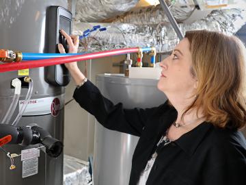 ORNL researcher Heather Buckberry adjusts settings on a home appliance. Smart appliances and heating/cooling systems are designed to give homeowners the ability to closely manage electricity usage. 