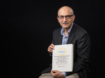 ORNL researcher Moonis Ally with his published theory: "Thermodynamics of Highly Concentratied Aqueous Electrolytes."