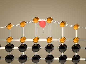 Inserting helium atoms (visualized as a red balloon) into a crystalline film (gold) allowed Oak Ridge National Laboratory researchers to control the material’s elongation in a single direction. 