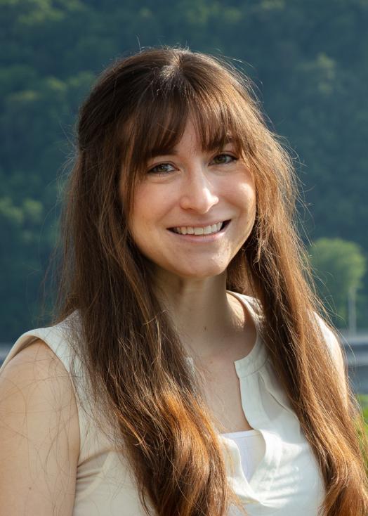 ORNL researcher Carly Hansen poses next to Melton Hill Dam