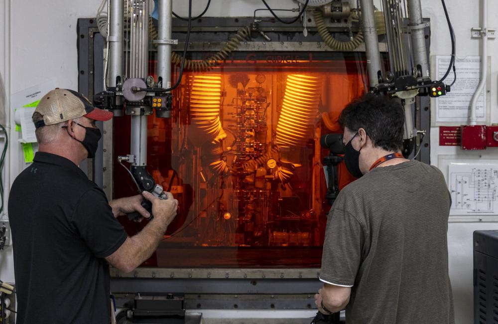 Technicians at a hot cell facility in the REDC