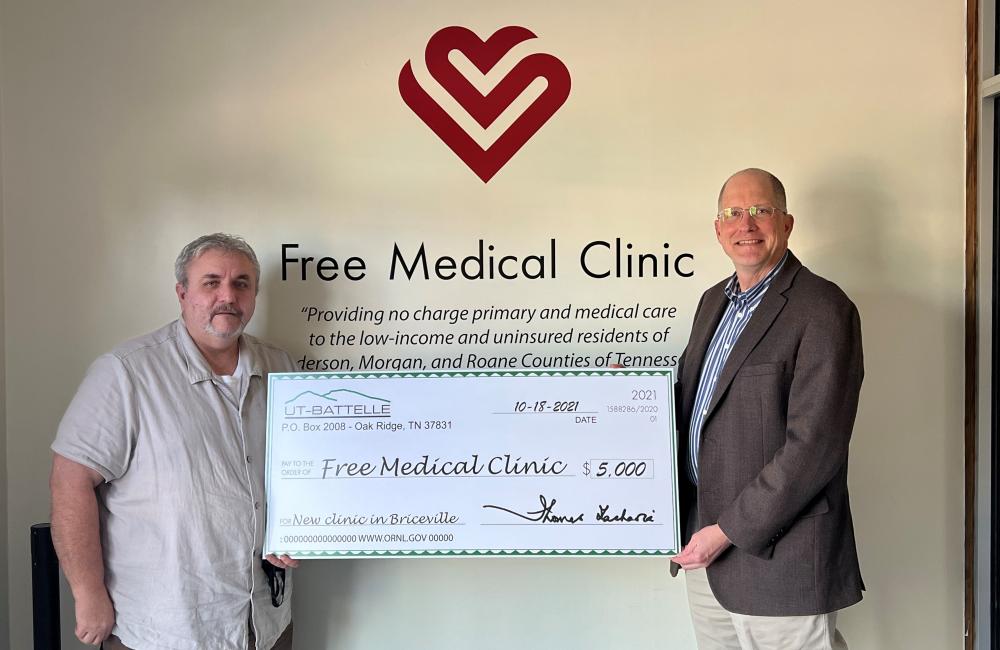 Alan Icenhour, right, ORNL deputy director for laboratory operations, presents Billy Edmonds, executive director of the Free Medical Clinic, with a check during a celebration on Oct. 18 in Briceville. Credit: ORNL, U.S. Dept. of Energy