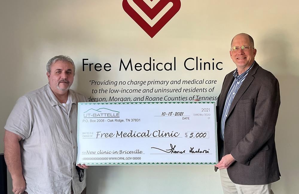 Alan Icenhour, right, ORNL deputy director for laboratory operations, presents Billy Edmonds, executive director of the Free Medical Clinic, with a check during a celebration on Oct. 18 in Briceville. Credit: ORNL, U.S. Dept. of Energy